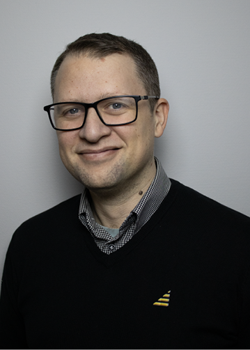 Man med kort hår och glasögon.