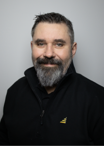 Man med kort hår och skägg.